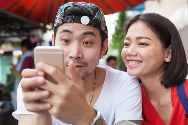 Asiatico più giovane uomo e donna guardando su smart phone uso per peop — Foto Stock