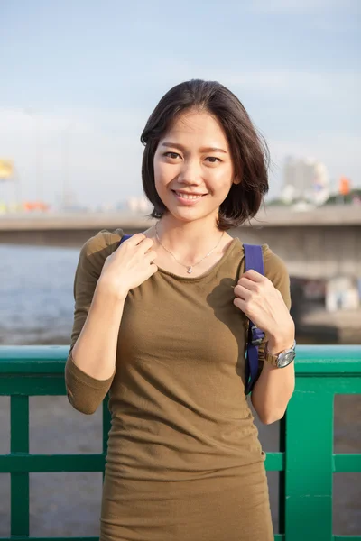 Hlavou střílel usmívající se tvář asijské ženy s batohem, stojící — Stock fotografie