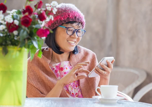 40 Jahre Glücksempfinden einer Frau auf dem Smartphone — Stockfoto