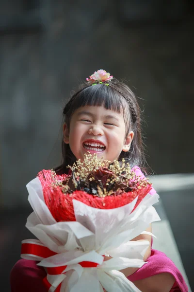 Asian girl with dry flower bouquet in hand laughing with happine — Stock Photo, Image