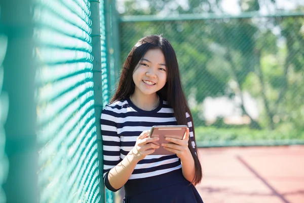 Asiatico ragazza e computer tablet in mano in piedi con dentato smil — Foto Stock