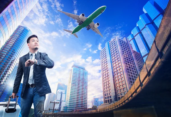 Young business man standing against urban building scene looking — Stock Photo, Image