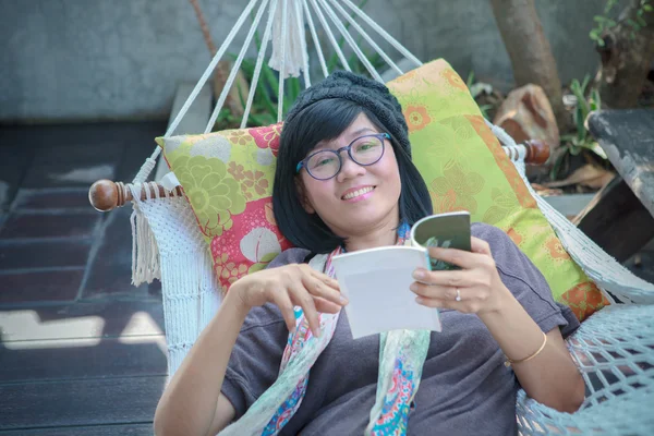 Портрет красивої азіатської жінки, що розслабляє час читання книги на — стокове фото
