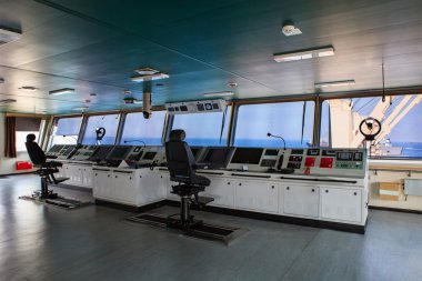 wheelhouse control board of modern industry ship approaching to  clipart