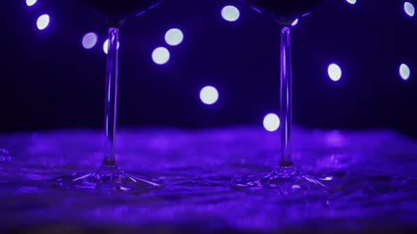 Due bicchieri di vino vuoti sul tavolo con la luce blu — Video Stock