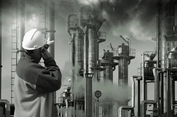 Trabajador petrolero apuntando a una gran refinería — Foto de Stock