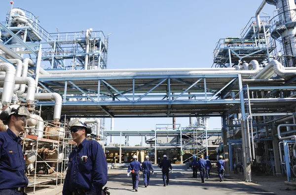 Trabajadores de refinerías dentro de una gran planta de la industria petrolera — Foto de Stock