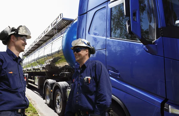 Finomítói munkavállalók és nagy üzemanyag-truck — Stock Fotó