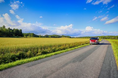 Car driving on beautiful country road clipart
