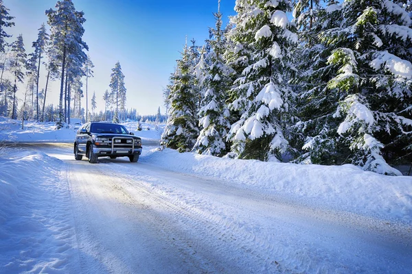 Geländewagen fährt in rauem, schneebedecktem Gelände lizenzfreie Stockbilder