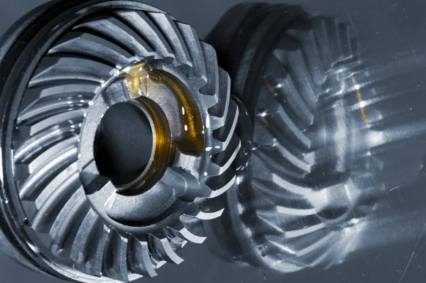 Titanium cogwheel mirrored in titanium background — Stock Photo, Image