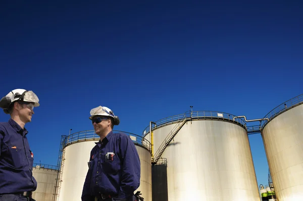 Trabajadores del petróleo y tanques de almacenamiento de combustible — Foto de Stock