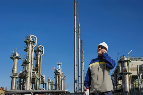 Trabalhador de petróleo com grande refinaria no fundo — Fotografia de Stock