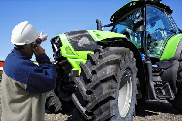 Giant farming tractor with mechanic Stock Photo