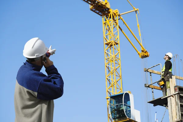 Costruttore directing crane operator — Foto Stock