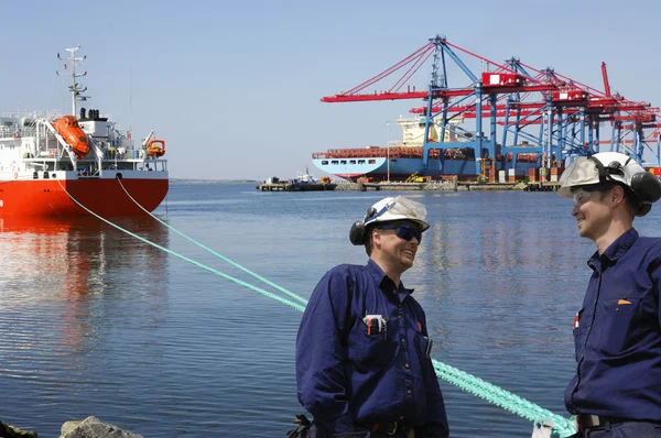 Trabalhadores portuários de contentores e navios atracados — Fotografia de Stock