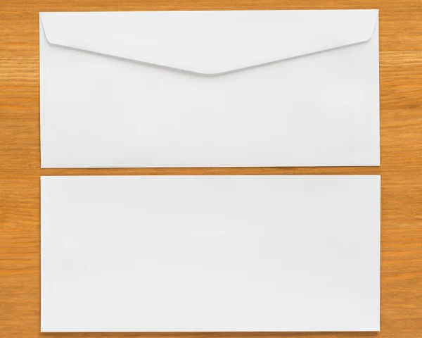 Envelope branco sobre fundo de madeira — Fotografia de Stock