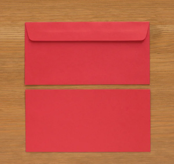 木材の背景に赤い封筒 — ストック写真