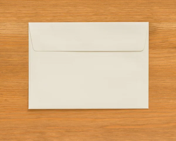 Белый конверт на деревянном фоне — стоковое фото