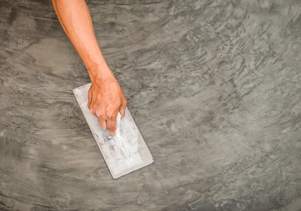 Hand mit Stahlkelle, um polierte nasse Betonoberfläche zu beenden — Stockfoto