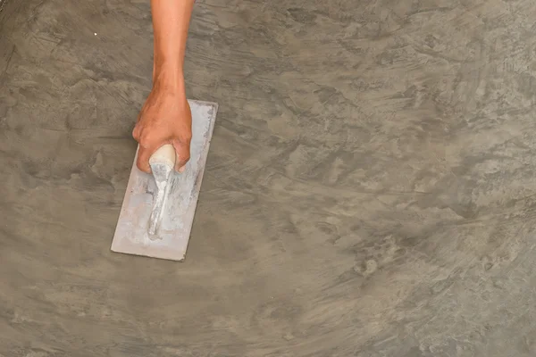 hand using steel trowel to finish Polished wet concrete surface