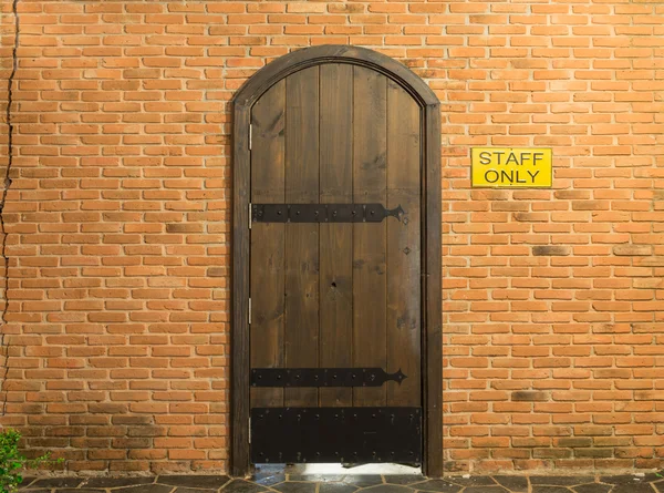 Wood arch door on red brick wall