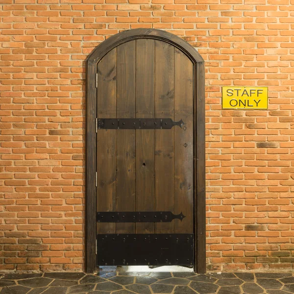 Porta de arco de madeira na parede de tijolo vermelho — Fotografia de Stock