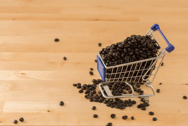 木材の背景にカートで茶色のコーヒー豆 — ストック写真