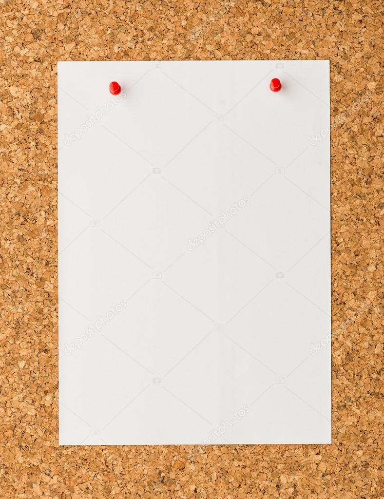 white paper note sheet with red push pin on cork board 