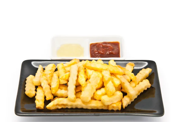 Patatine fritte in piatto nero — Foto Stock