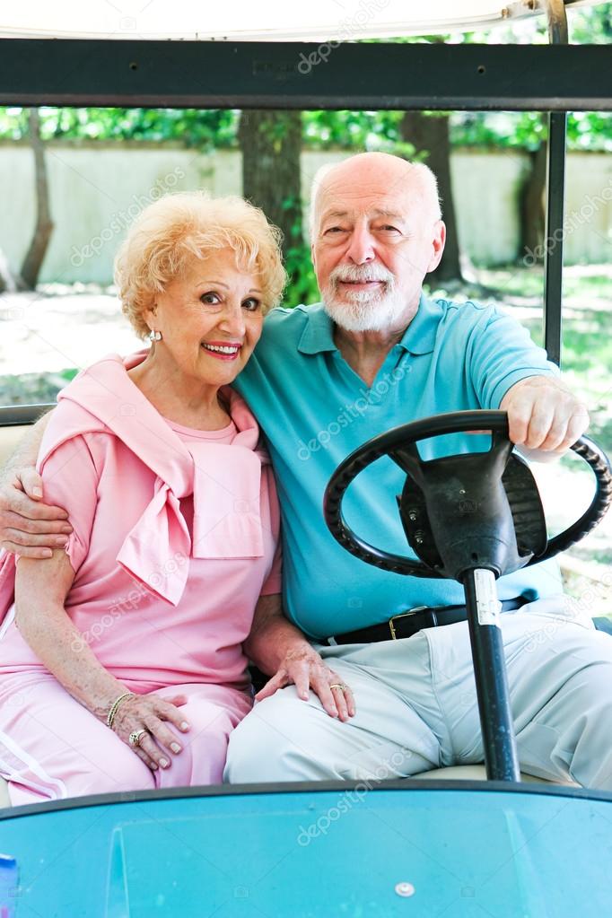 Senior Couple Drives Golf Cart