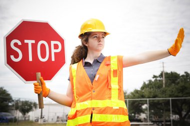 Kadın inşaat işçisi trafiğini yönlendirir