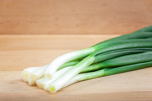 Fresh green onions on a wooden board — Stock Photo, Image