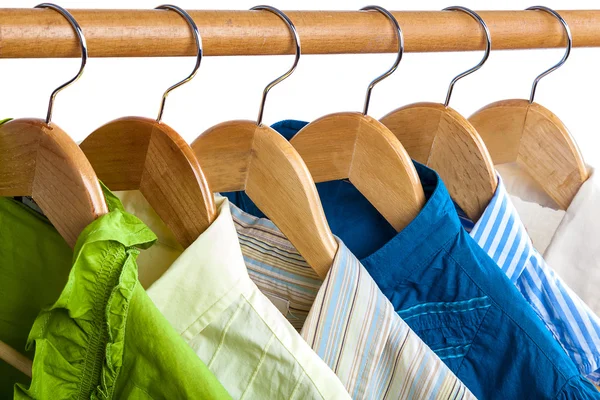 Clothes on wooden hangers on white. — Stock Photo, Image