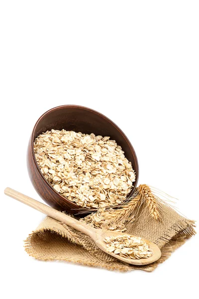 Oat flakes in ceramic bowl with wooden spoon — Stock Photo, Image