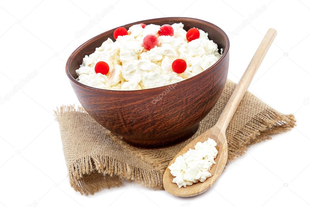 Cottage cheese in a bowl and a wooden spoon