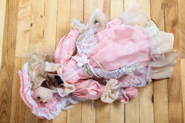 Broken doll on a wooden floor. — Stock Photo, Image
