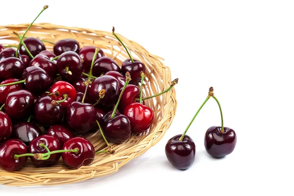 Cerezas frescas en un plato de mimbre . —  Fotos de Stock