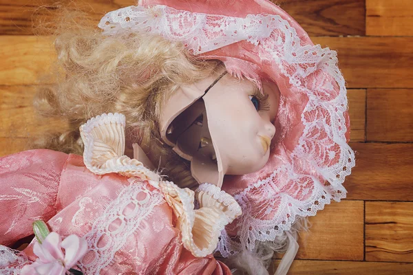 Broken doll on a wooden floor. — Stock Photo, Image