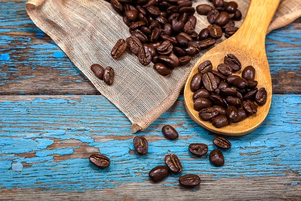 Granos de café con una cucharada de madera . —  Fotos de Stock