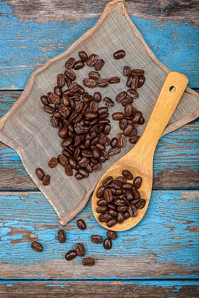 Grains de café avec une cuillère en bois . — Photo