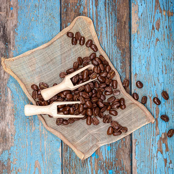 Kávová zrna s dřevěnou lopatkou. — Stock fotografie