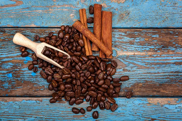 Kaffebönor med kanelstänger och scoop. — Stockfoto