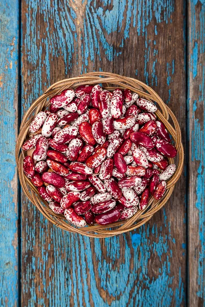 Haricots avec une cuillère sur une planche en bois . — Photo