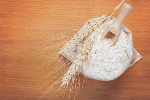 Mehl in einem Leinensack und Weizenähren. — Stockfoto