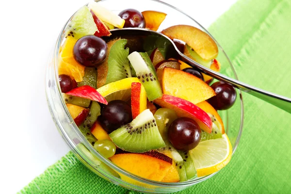 Insalata di frutta fresca e bacche su un panno verde . — Foto Stock