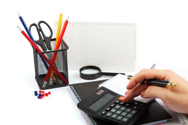 Hand with pen and calculator, notepad and office supplies. clipart