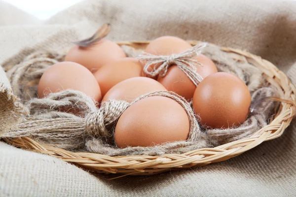 Eieren in een mand op doek zak. — Stockfoto