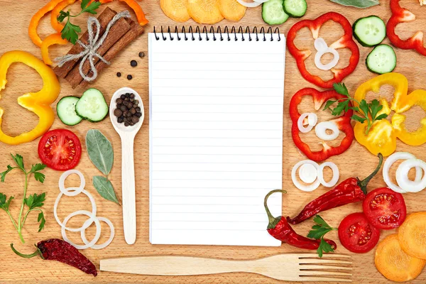 Vegetables, spices and notepad for recipes, on table. — Stock Photo, Image