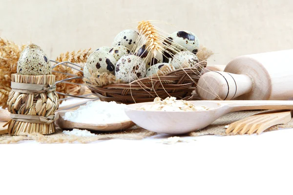 Huevos de codorniz, harina y utensilios de cocina sobre lienzo . — Foto de Stock